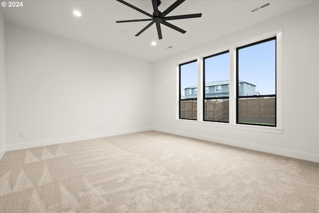 carpeted spare room featuring ceiling fan