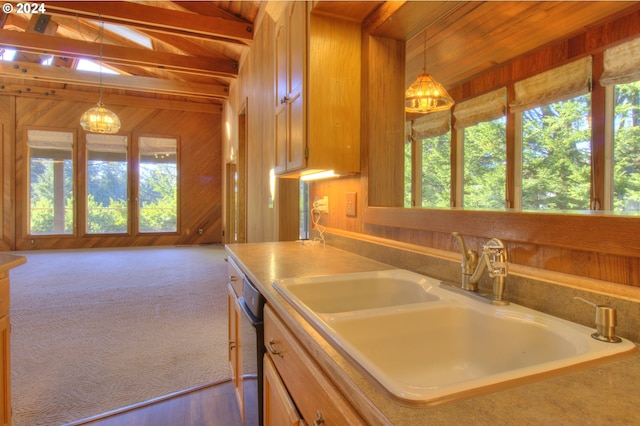 kitchen with sink, dishwasher, vaulted ceiling with beams, wood walls, and decorative light fixtures