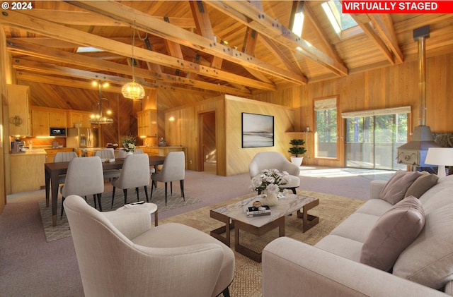 carpeted living room with beamed ceiling, high vaulted ceiling, wooden walls, and a notable chandelier