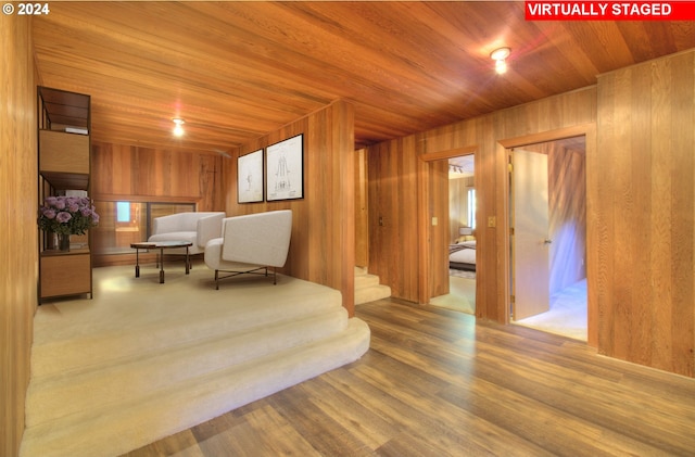 sitting room featuring wood-type flooring, wooden walls, and wooden ceiling