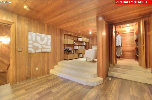 stairway featuring hardwood / wood-style floors, wood walls, and wood ceiling