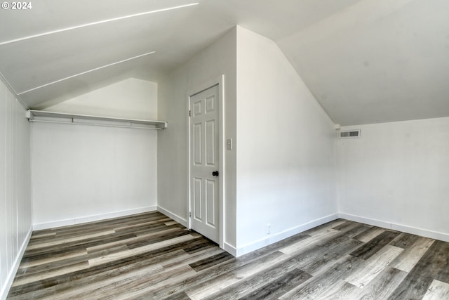 additional living space with dark hardwood / wood-style floors and vaulted ceiling