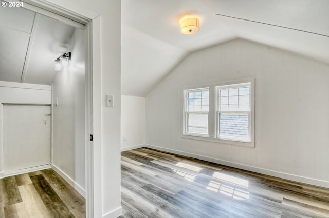 additional living space with lofted ceiling and hardwood / wood-style floors