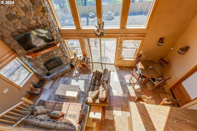 living room with a towering ceiling, plenty of natural light, a fireplace, and stairway