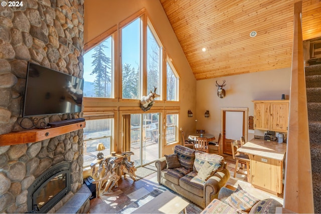 living area featuring high vaulted ceiling, plenty of natural light, wood ceiling, and a fireplace