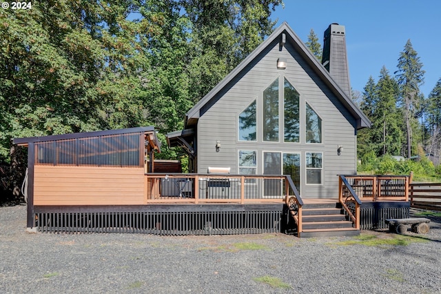 rear view of property featuring a chimney and a wooden deck