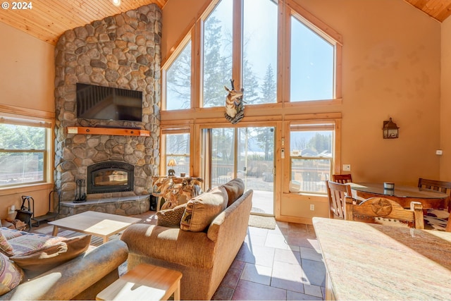 living room featuring wooden ceiling, a fireplace, and high vaulted ceiling