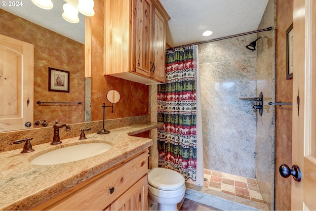 bathroom featuring toilet, a stall shower, and vanity