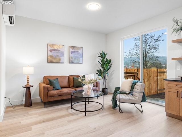 living room with a wall mounted air conditioner and light hardwood / wood-style floors