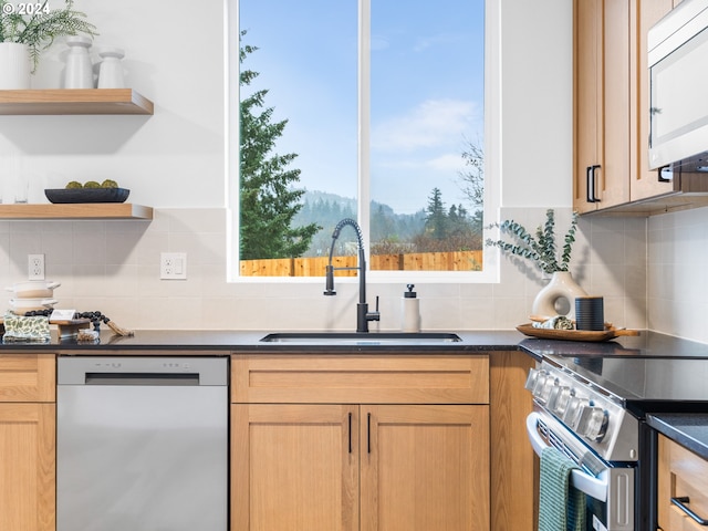 kitchen featuring decorative backsplash, sink, and appliances with stainless steel finishes