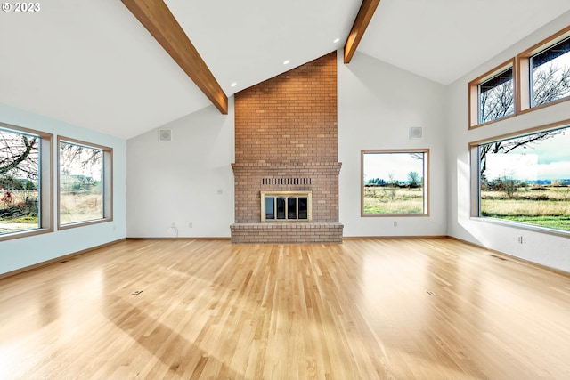 unfurnished living room featuring vaulted ceiling with beams, a brick fireplace, and hardwood / wood-style flooring