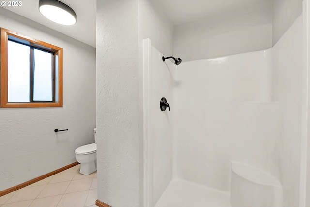 bathroom with tile patterned floors, a shower, and toilet