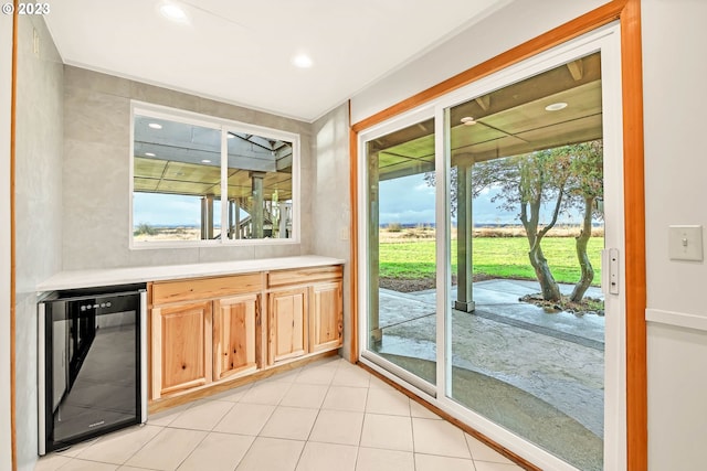 kitchen featuring light brown cabinetry, a wealth of natural light, and beverage cooler