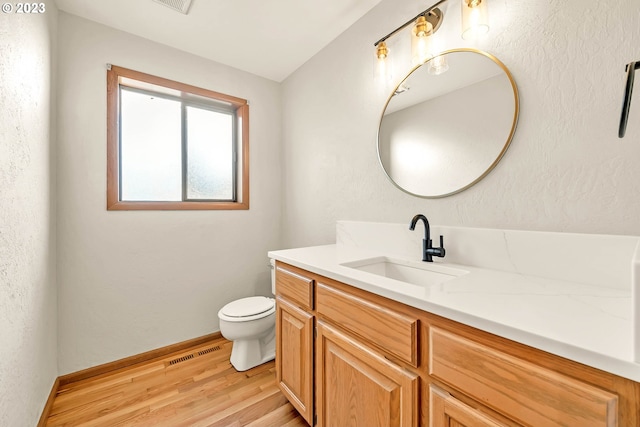 bathroom with vanity, hardwood / wood-style flooring, and toilet