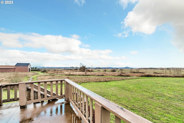 deck featuring a lawn and a rural view