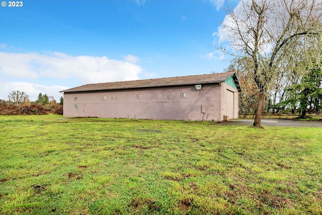 view of side of property with an outbuilding, a garage, and a lawn