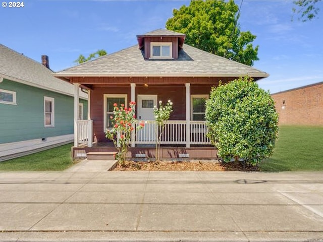 view of front of home with covered porch and a front yard