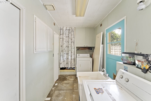 laundry room with cabinets, sink, and washer and dryer