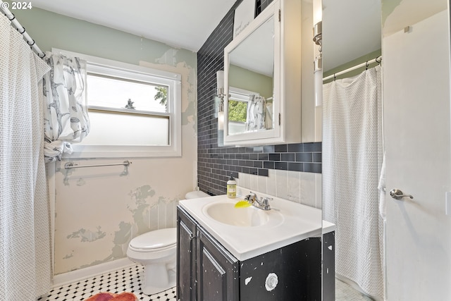 bathroom with tile patterned flooring, vanity, toilet, and tile walls