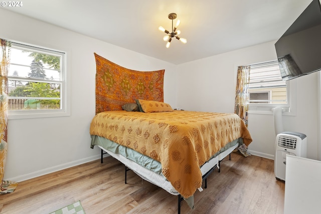 bedroom with an inviting chandelier and hardwood / wood-style flooring