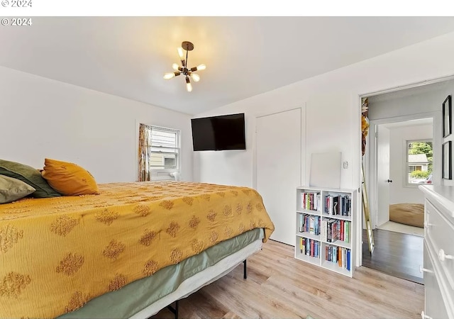 bedroom featuring hardwood / wood-style floors, an inviting chandelier, and multiple windows