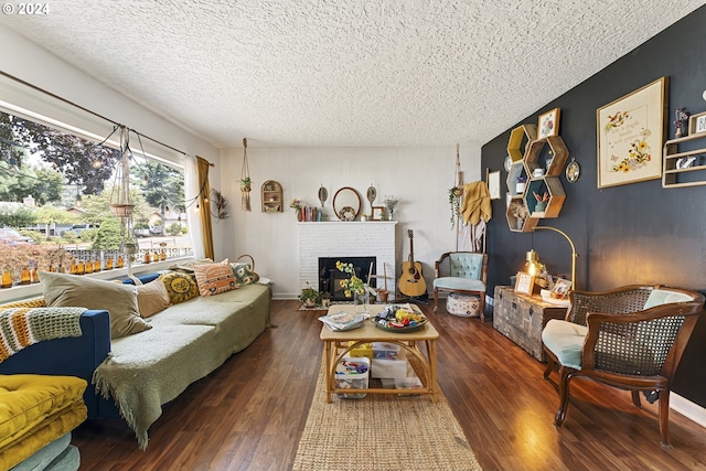 living room with a fireplace, a textured ceiling, and dark hardwood / wood-style flooring