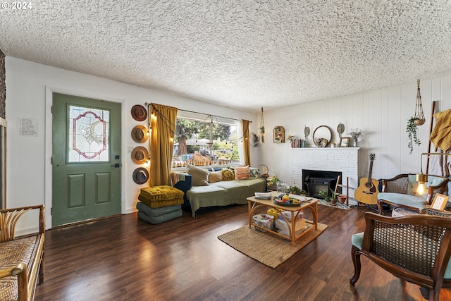 living room featuring a fireplace, a textured ceiling, and dark wood-type flooring