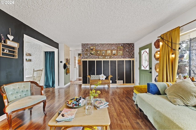 living room with a textured ceiling and dark hardwood / wood-style floors