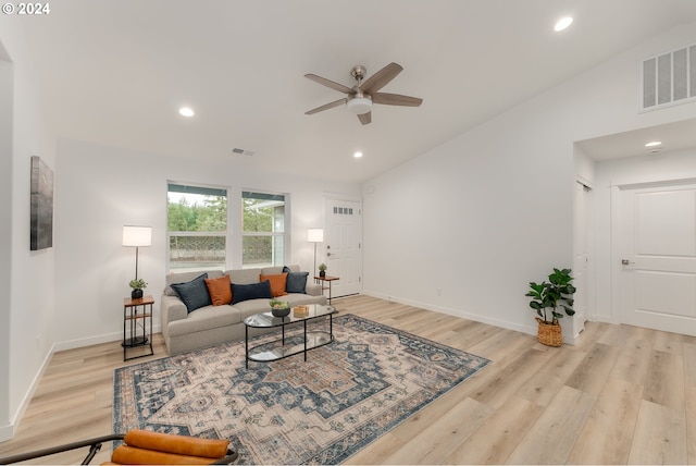 living room featuring ceiling fan, light hardwood / wood-style flooring, and lofted ceiling