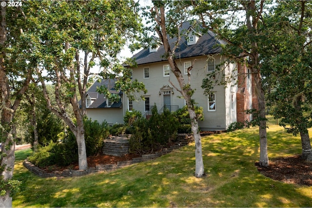 rear view of house featuring a lawn