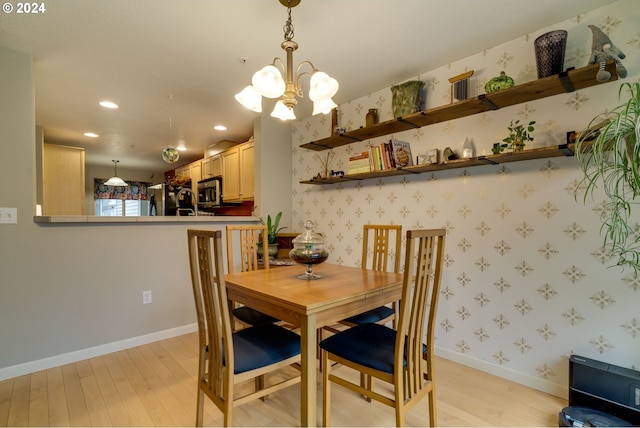 dining area with light hardwood / wood-style flooring and a chandelier