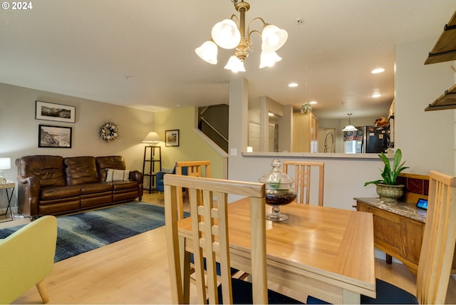 dining space with a notable chandelier and light hardwood / wood-style floors