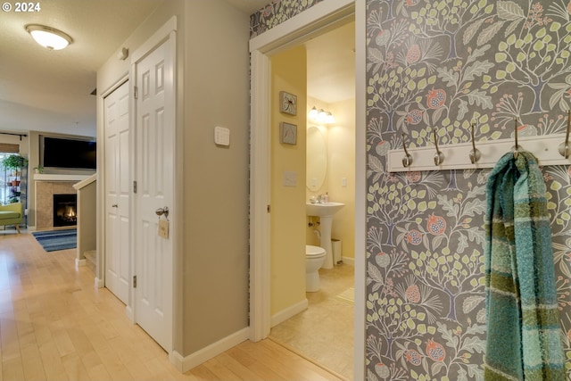 hallway with a textured ceiling and light wood-type flooring