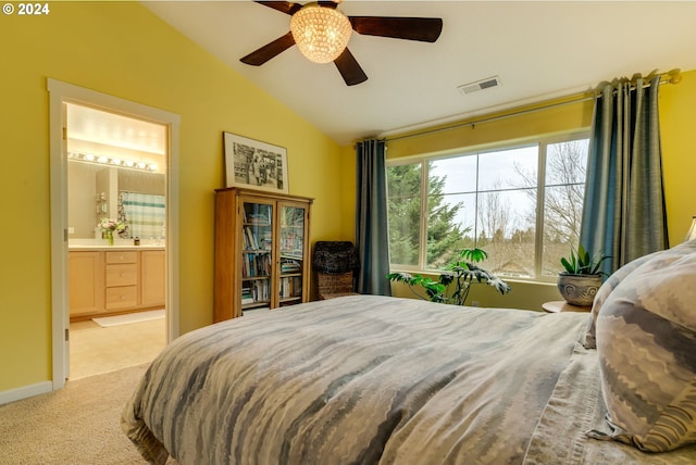 bedroom with ceiling fan, lofted ceiling, light carpet, and ensuite bath