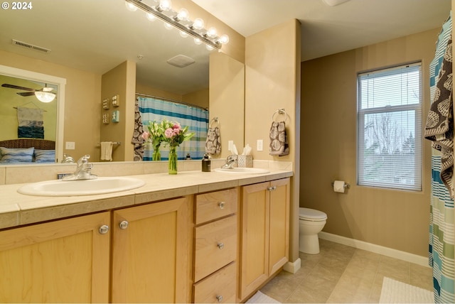 bathroom featuring tile patterned flooring, vanity, ceiling fan, and toilet