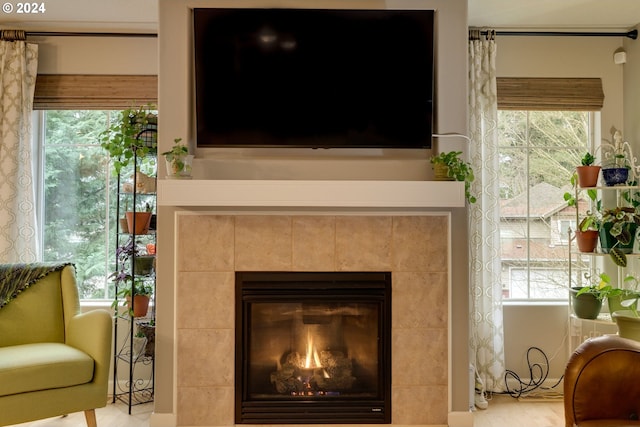 interior details featuring a tile fireplace