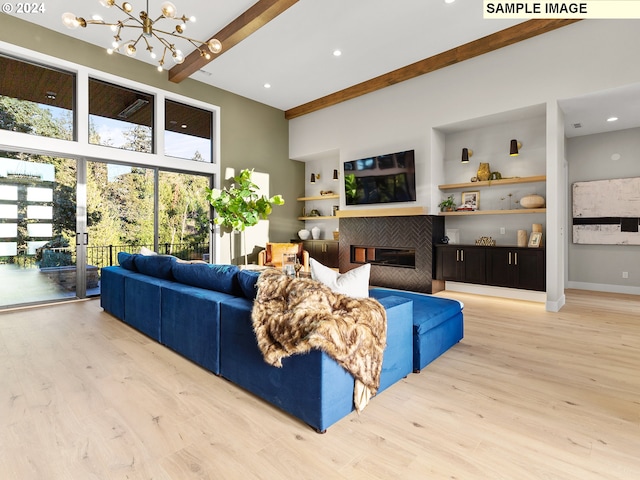 living room featuring an inviting chandelier, a fireplace, beamed ceiling, a towering ceiling, and wood finished floors