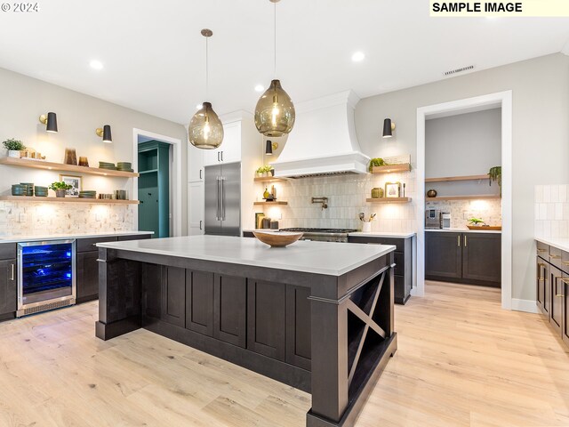 kitchen with wine cooler, stainless steel built in fridge, open shelves, and custom exhaust hood