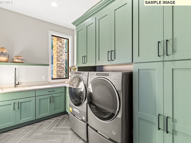 washroom featuring cabinet space, recessed lighting, washing machine and dryer, and a sink