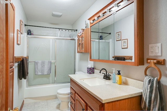 full bathroom with toilet, tile patterned flooring, vanity, and combined bath / shower with glass door