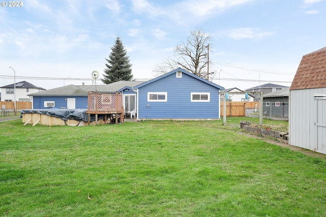 back of property featuring a yard and a covered pool