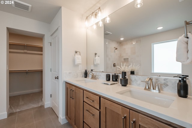 3255 SE Farrow Ln, Hillsboro, OR 97123 - full bathroom with tile patterned flooring, double vanity, a tile shower, a spacious closet, and tasteful backsplash