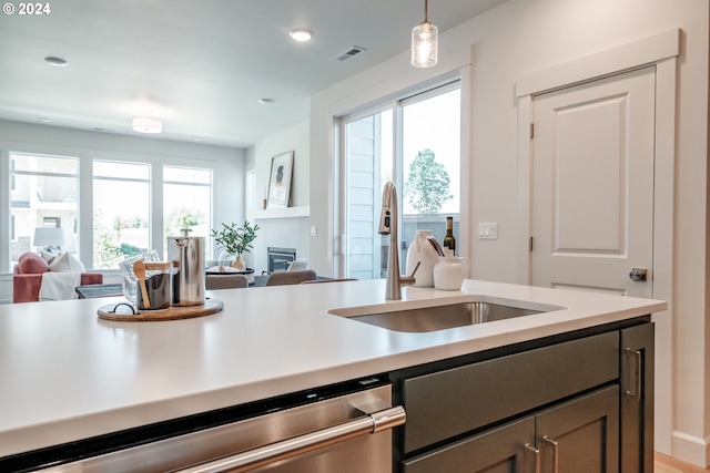 kitchen featuring sink, stainless steel dishwasher, and pendant lighting