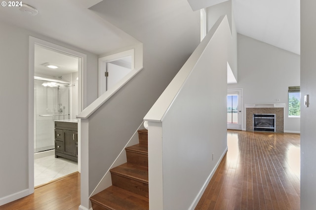 stairs featuring a towering ceiling and hardwood / wood-style floors