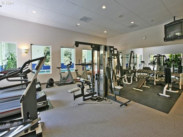 gym featuring a paneled ceiling and carpet