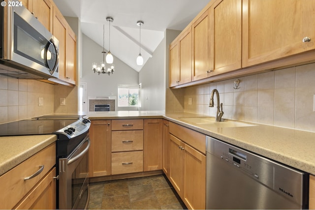 kitchen featuring lofted ceiling, sink, stainless steel appliances, an inviting chandelier, and decorative backsplash