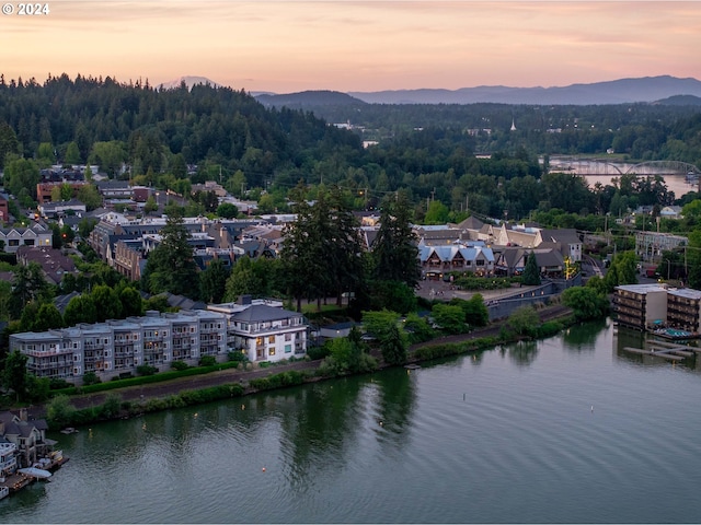 aerial view at dusk featuring a water view