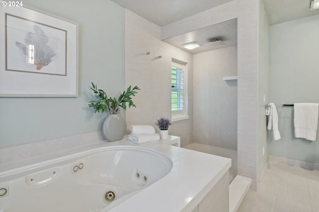 bathroom featuring a tub with jets, tile patterned flooring, and a tile shower