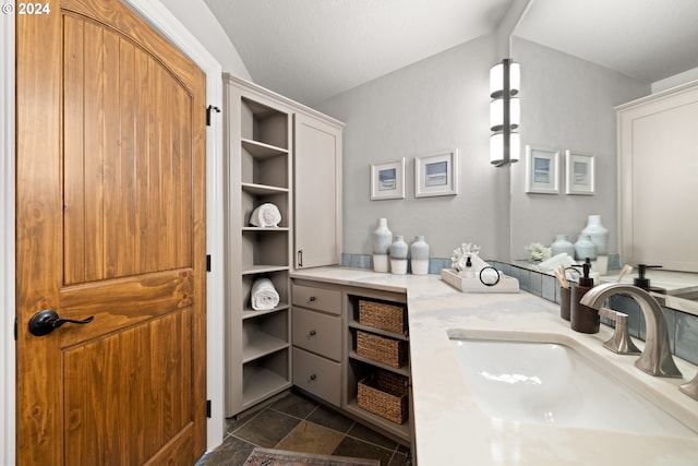 bathroom featuring vaulted ceiling and vanity