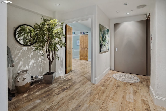 foyer entrance featuring baseboards and wood finished floors